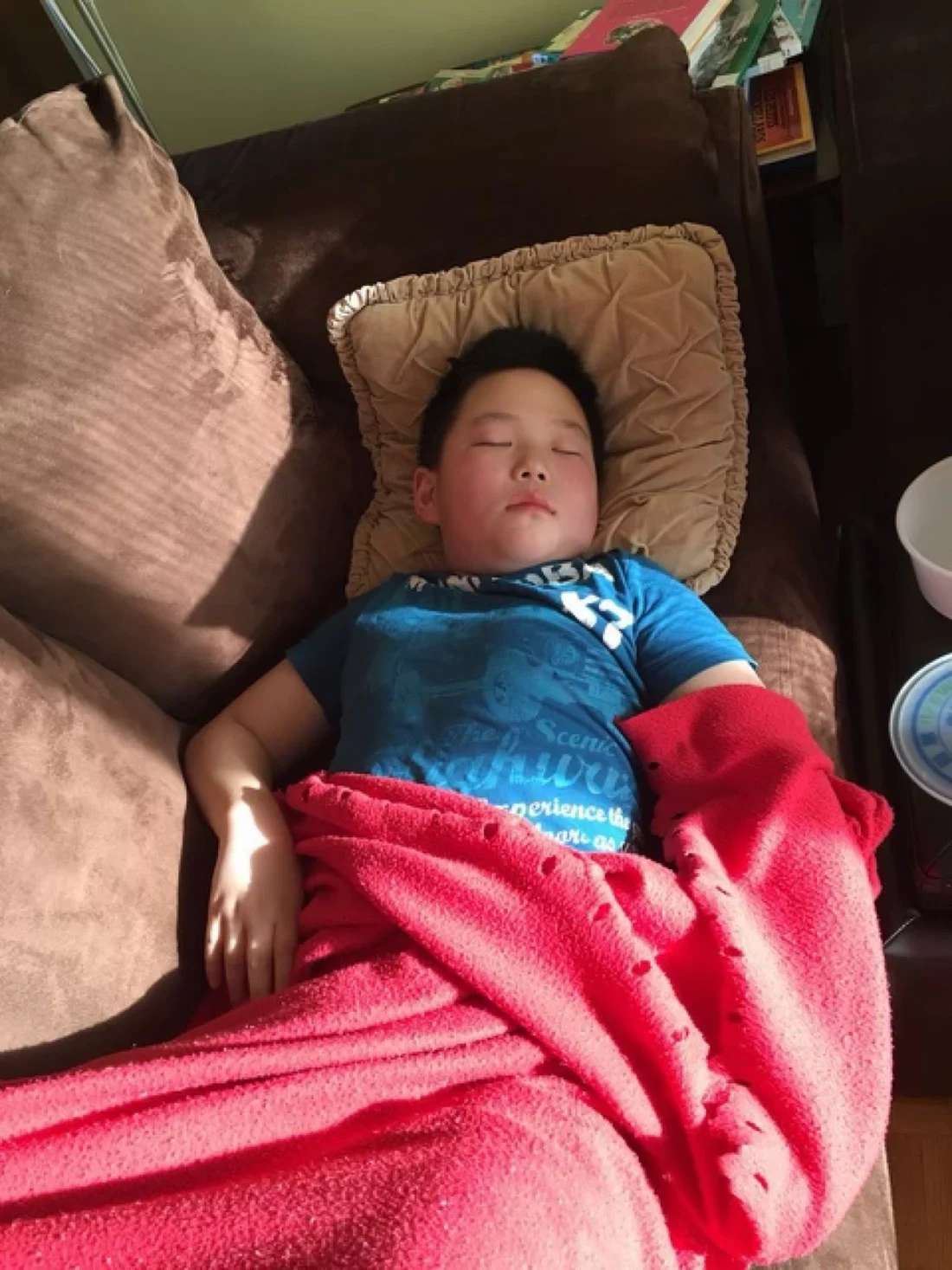 A childhood photo, asleep under a red blanket
