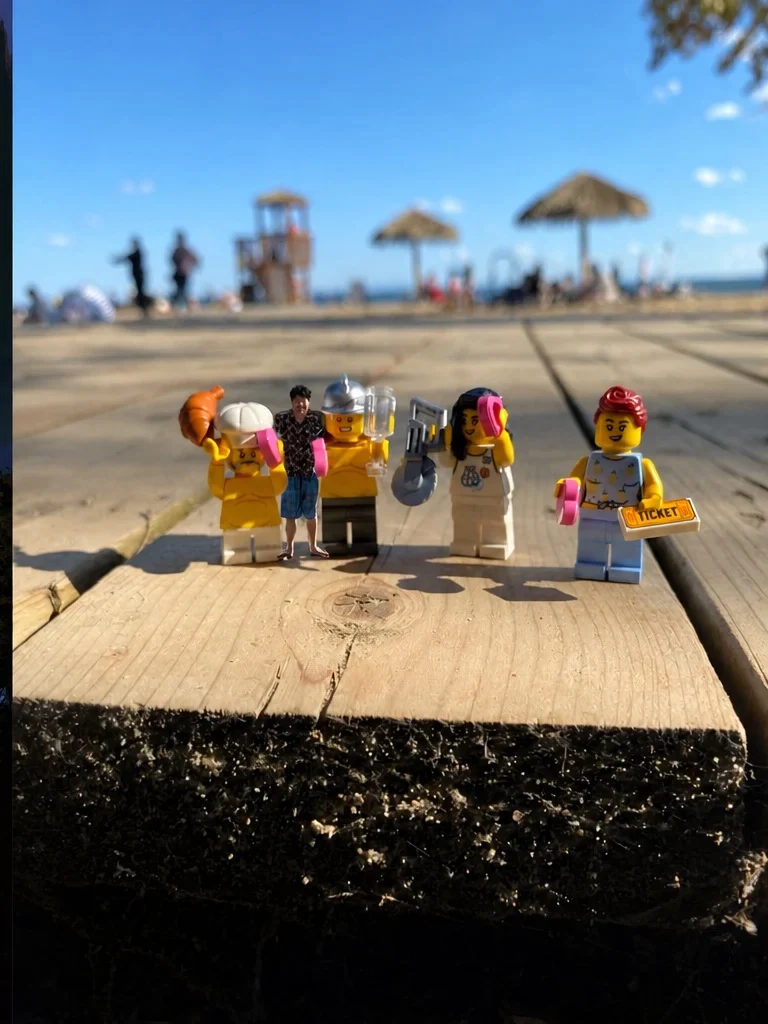 Four LEGO figures lined up on a boardwalk at the beach