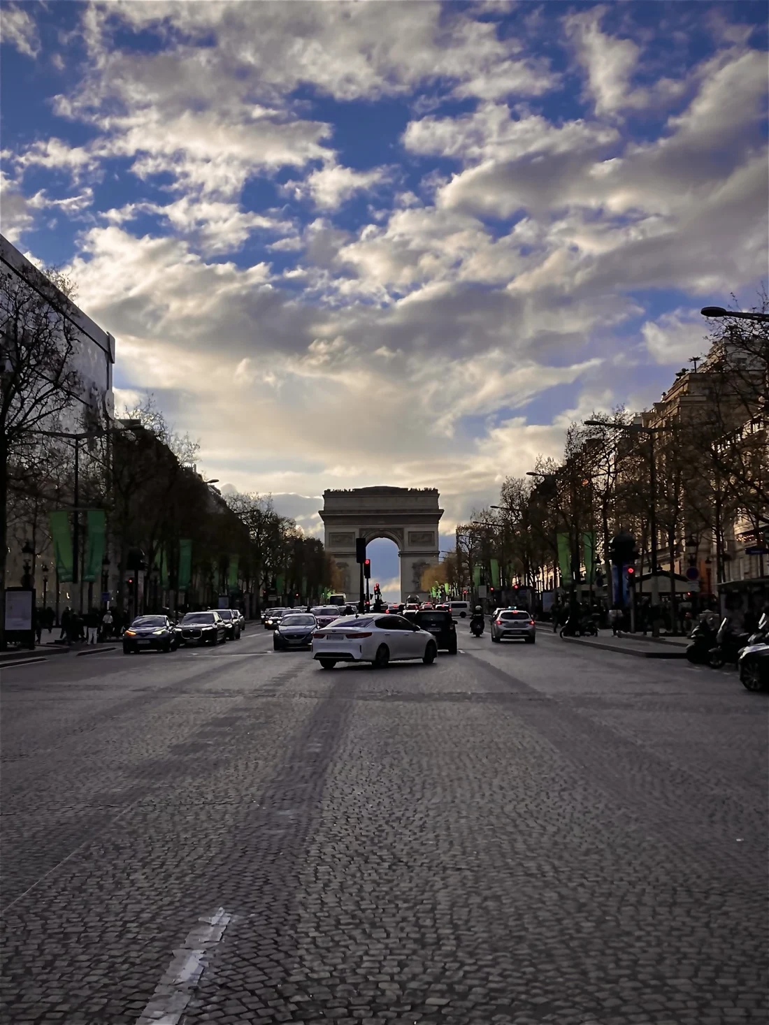 The Arc de Triomphe beneath a cloud-streaked sky