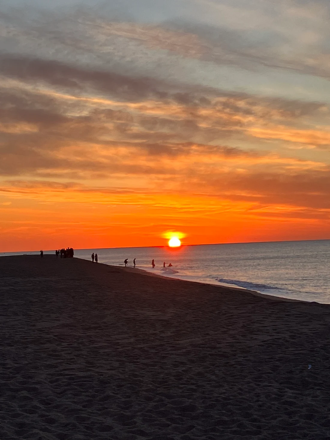 An orange sunset over the sea and a quiet beach
